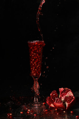 pomegranate wine in the glass on the black backgroundの写真素材