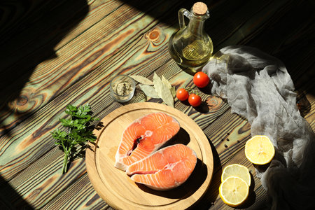 Fresh salmon steak with ingredients on dark wooden backgroundの写真素材