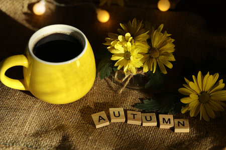 cup of coffee on the autumn background with leaves and flowers. Text Autumnの写真素材