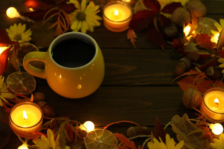 cup of coffee on the autumn background with leaves and flowersの写真素材