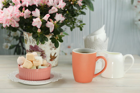 cup of coffee with marshmallow on white wooden tableの写真素材