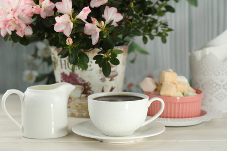 cup of coffee with marshmallow on white wooden tableの写真素材