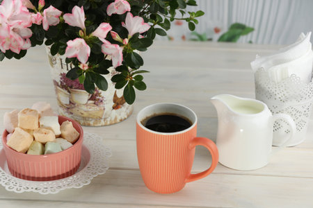 cup of coffee with marshmallow on white wooden tableの写真素材