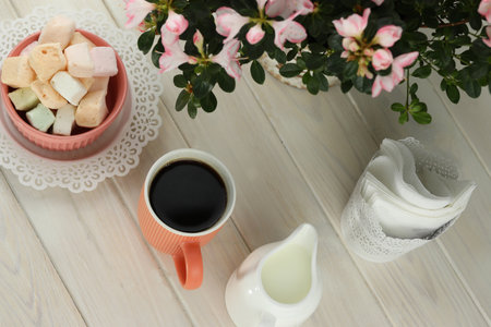 cup of coffee with marshmallow on white wooden tableの写真素材