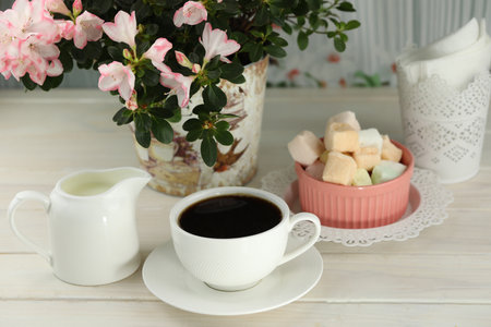 cup of coffee with marshmallow on white wooden tableの写真素材