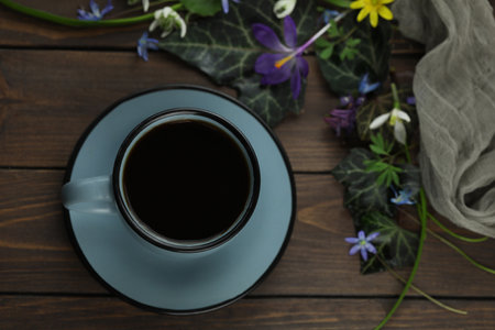brown wooden background with spring flowers, leaves and coffeeの写真素材