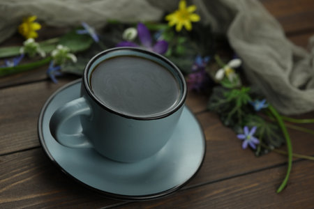 brown wooden background with spring flowers, leaves and coffeeの写真素材