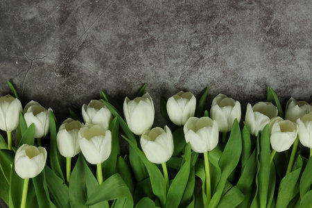 Beautiful bouquet of white tulip flowers with card on gray background, space for textの写真素材