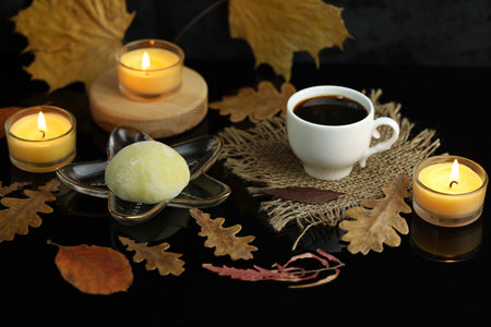 Colorful japanese sweets daifuku or mochi. Sweets close up on the plate with autumn leaves background and candlesの写真素材
