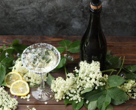Glass of champagne with elderflower liqueur. Decorated with white elder flowers in natural backgroundの写真素材