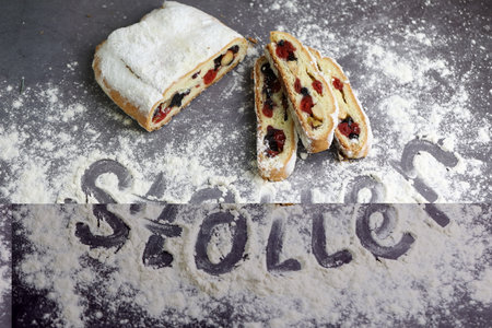 Sliced Chrismas stollen with powdered sugar and christmas decorationの写真素材