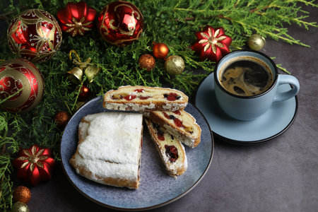 Sliced Chrismas stollen with powdered sugar and christmas decoration and cup of coffeeの写真素材