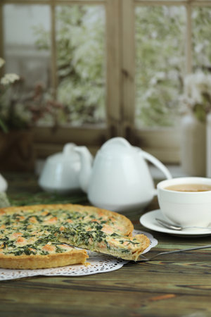Delicious Quiche pie with salmon fish and pine nuts filling. Breakfast with quiche and cup of teaの写真素材