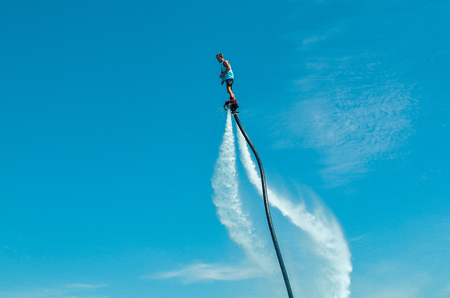 Belek, Turkey - September 12, 2018. Exciting fly board watershow on a sunny summer day. A man is doing acrobatics on flyboard with blue sky on the background.のeditorial素材