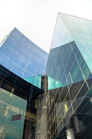 Low angle view of part of modern corporate building from glass with colorful reflections.の写真素材