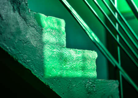 Green colored vintage green stairs part with sunlight as geometric shape made of light and shadow. Monochrome abstract background.の写真素材