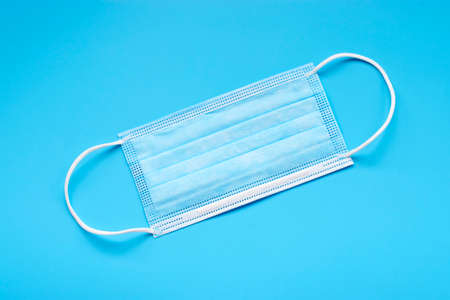 sterile medical mask on a blue background in the center.