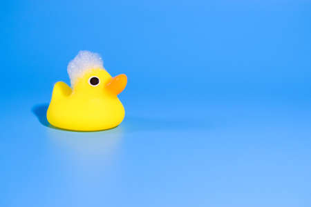 yellow duck for swimming with foam on a blue background.の写真素材