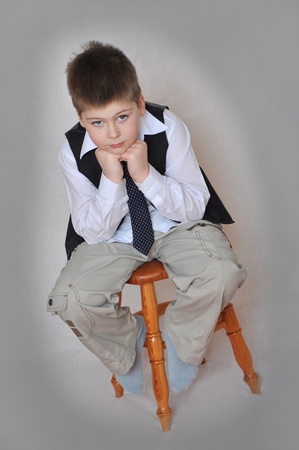 Portrait of a boy sitting on a chair の写真素材