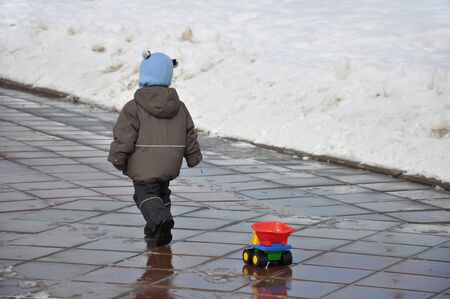 A child carries a plastic string trimmer の写真素材