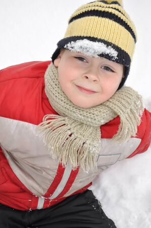 Portrait of a boy sitting in the snow の写真素材
