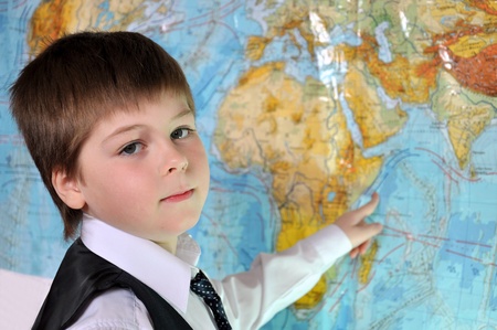 The boy is studying the physical map of the worldの写真素材