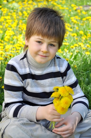 A boy with a bouquet of dandelionsの写真素材