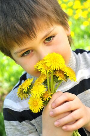 A boy with a bouquet of dandelionsの写真素材