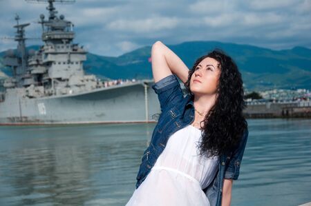 A beautiful young woman on the background of a shipの写真素材