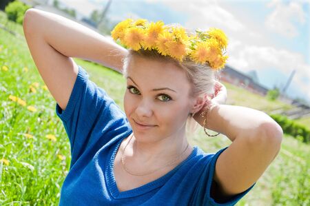 Beautiful girl with a wreath of dandelionsの写真素材