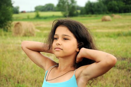 Beautiful girl in a field on a background of strawの写真素材