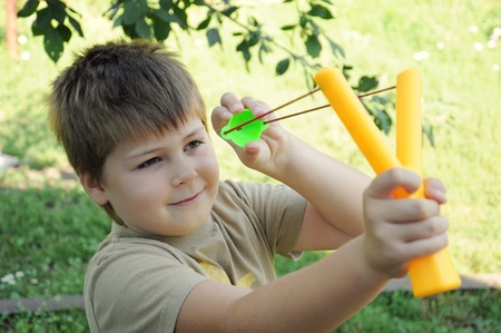 A boy plays with a left-handed catapultの写真素材
