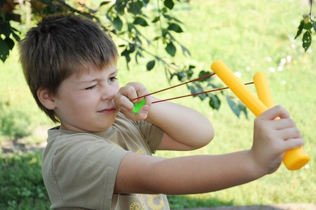 A boy plays with a left-handed catapultの写真素材