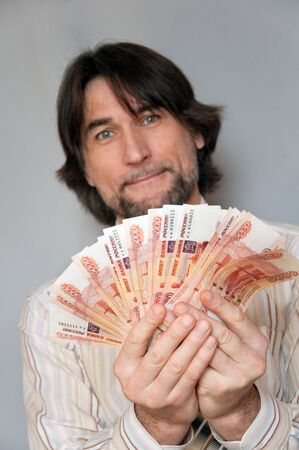 Funny man with a fan of Russian money in the hands ofの写真素材