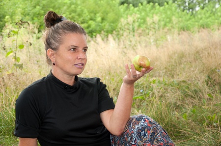 Middle-aged woman with an apple in his handの写真素材