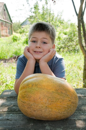 Boy with a big melon in his hand, harvestの写真素材