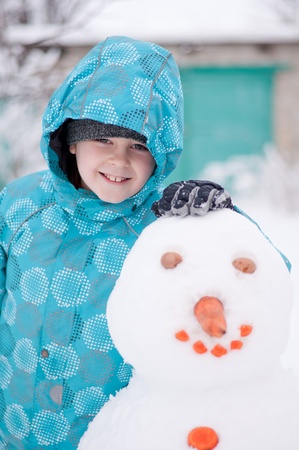 A boy and a snowman - a winter holidayの写真素材