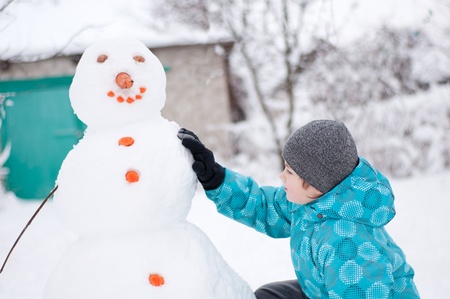 A boy and a snowman - a winter holidayの写真素材