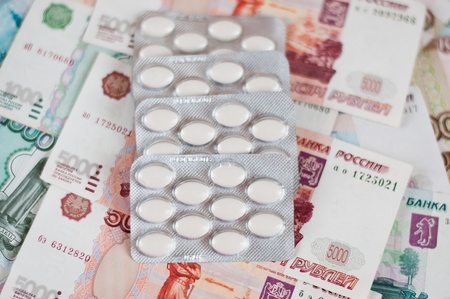 Tablets in a blister on the background of the moneyの写真素材