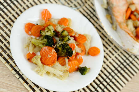 Tasty steamed vegetables on a white plateの写真素材