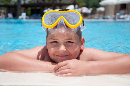 Boy with a mask for snorkeling in the poolの写真素材