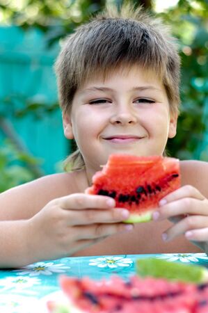 Boy eating a ripe watermelonの写真素材