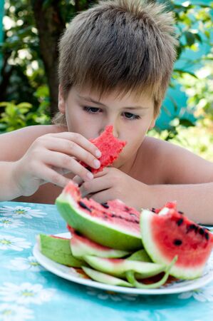 Boy eating a ripe watermelonの写真素材