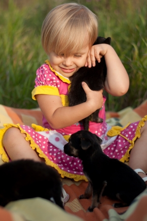 Little girl playing with puppiesの写真素材