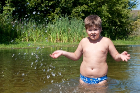 A boy swims in the riverの写真素材
