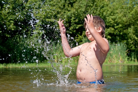A boy swims in the riverの写真素材