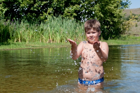 A boy swims in the riverの写真素材