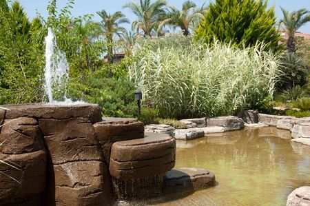 Landscaping - a stone fountain and pondの写真素材