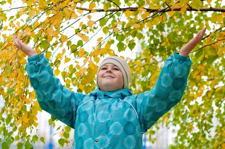 A boy in a birch forest in autumnの写真素材
