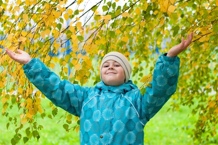 A boy in a birch forest in autumnの写真素材